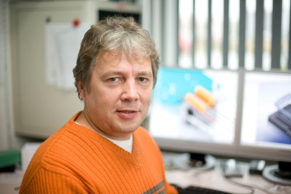 Mann mit Monitoren im Hindergrund